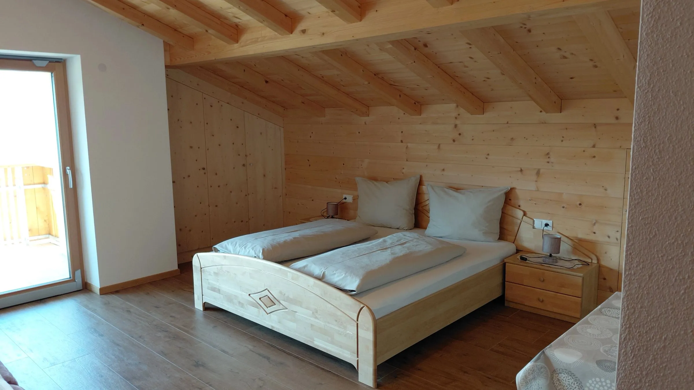 Schlafzimmer mit Panoramafenster und Blick auf Berg und Tal