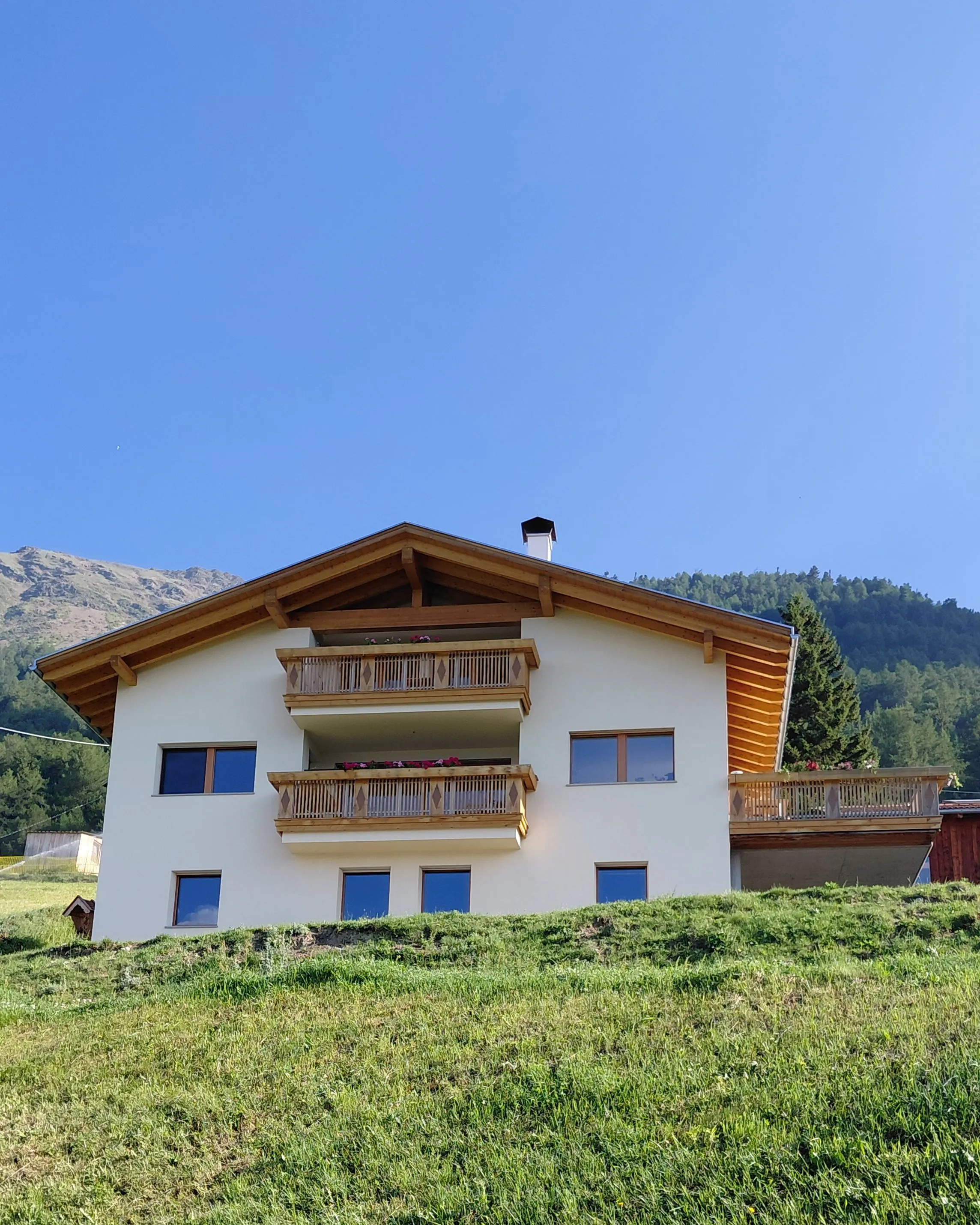 Der Frinighof am sonnigen Berghang oberhalb von Tanas